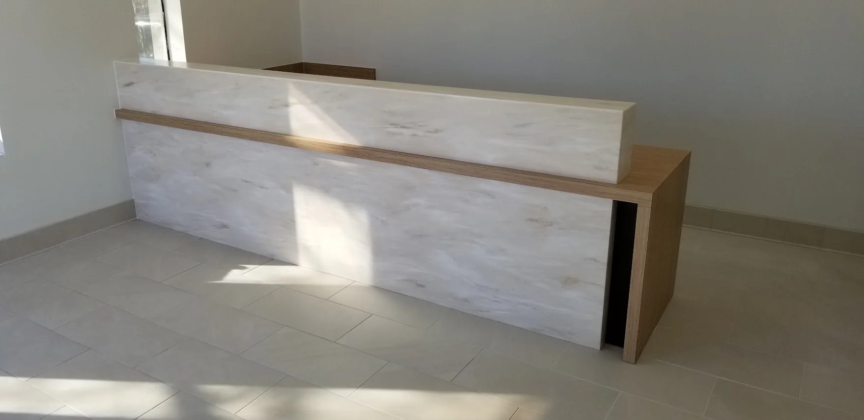 Laminate reception desk with a solid-surface transaction top and face